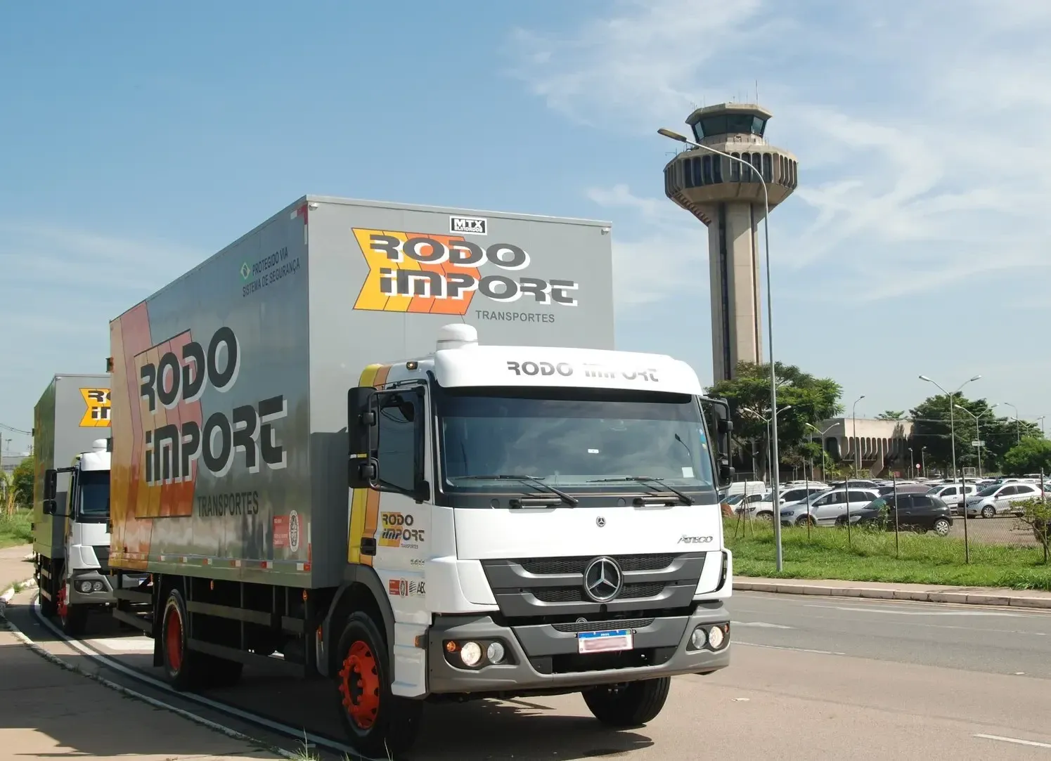 Caminhões da Rodo Import no Aeroporto Internacional de Viracopos, com a torre de controle ao fundo